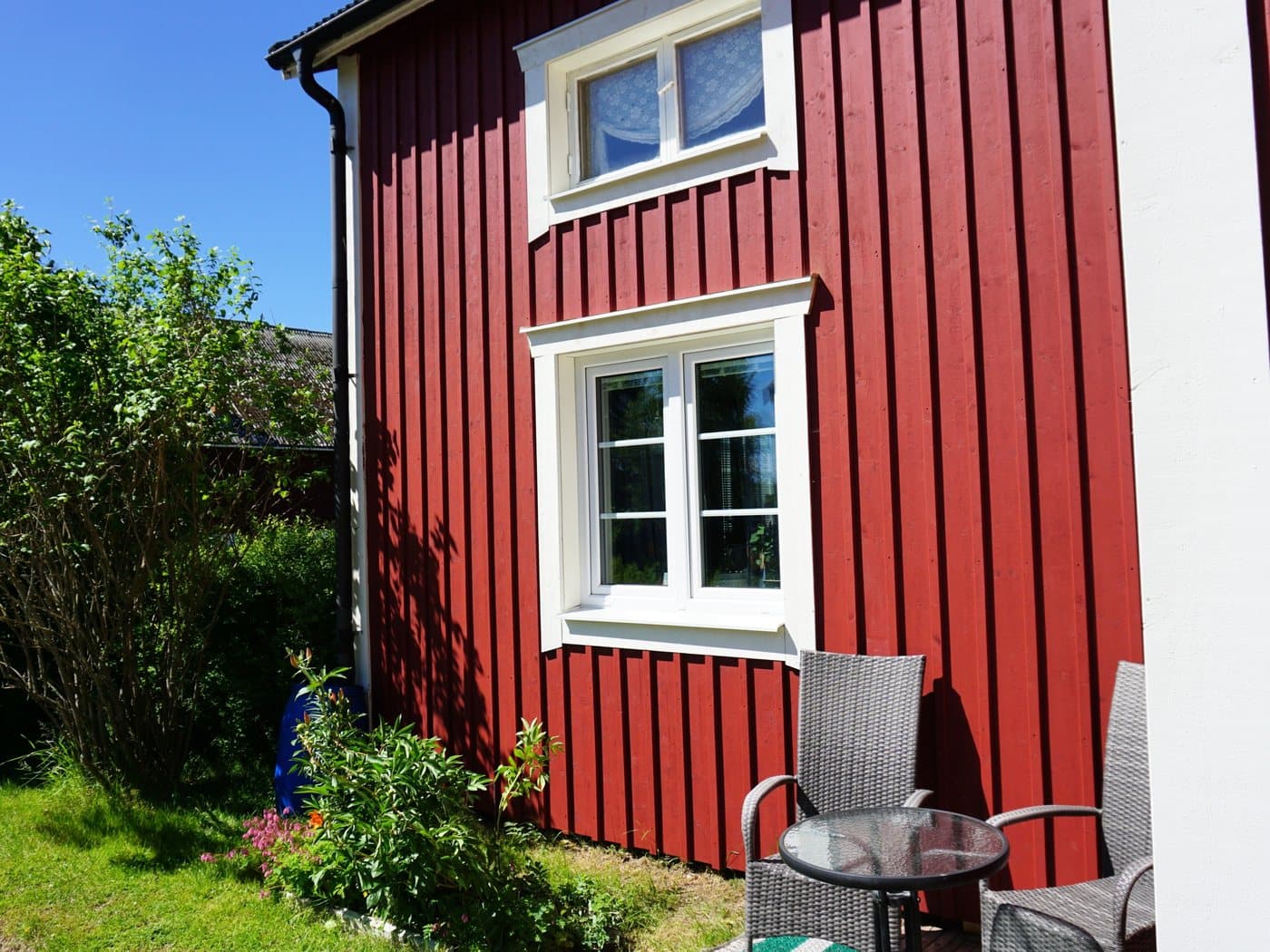 Falurött hus med nya vita fönster och uteplats