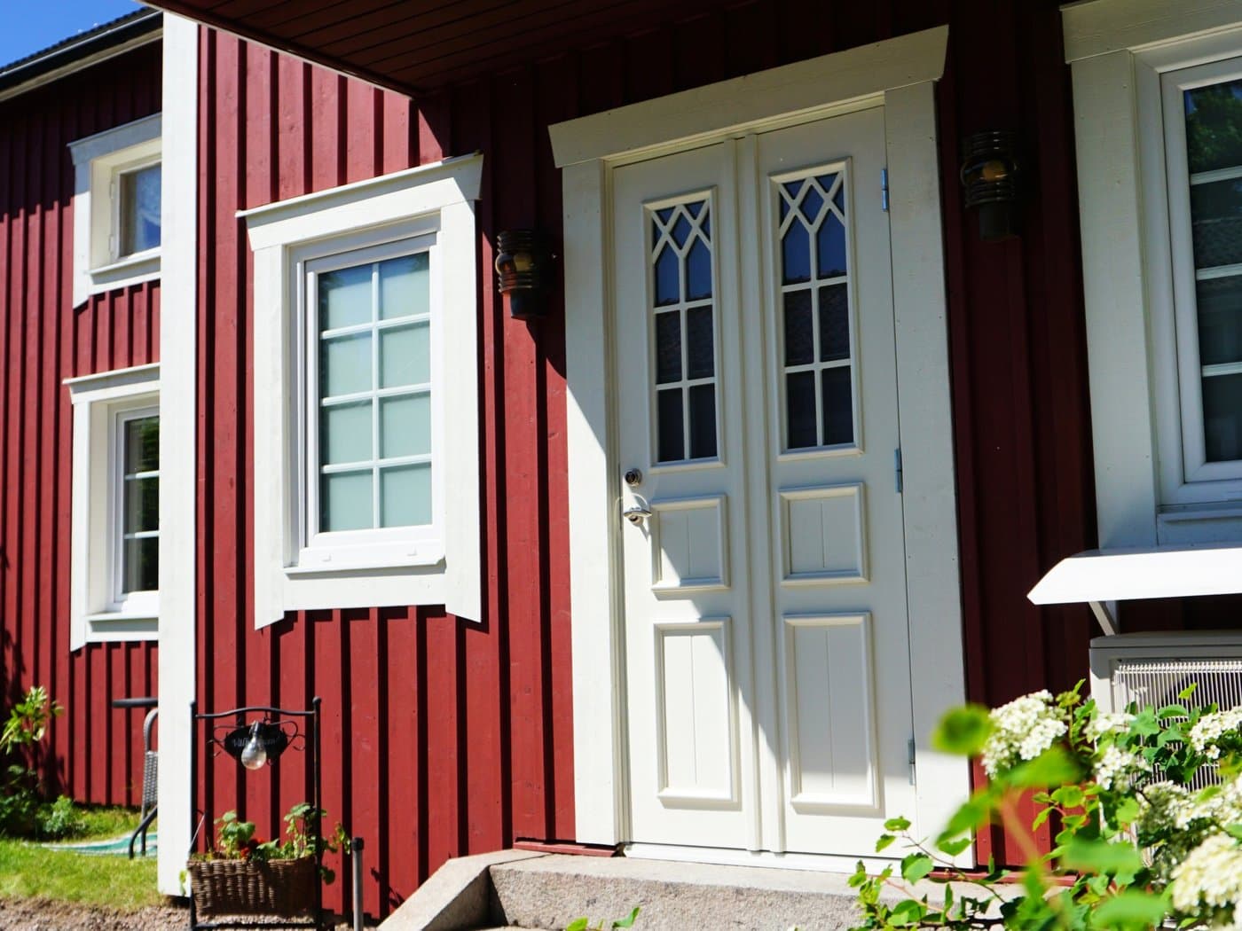 Ny vit ytterdörr i falurött hus